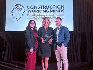 Photo of FTI receiving the Construction Working Minds - Mental Health Visionary Award. Pictured from left to right: Kayla Loughrin, FTI wellness program coordinator; Alyssa Kwasny, FTI wellness program director; Kyle Lang, FTI director of safety.