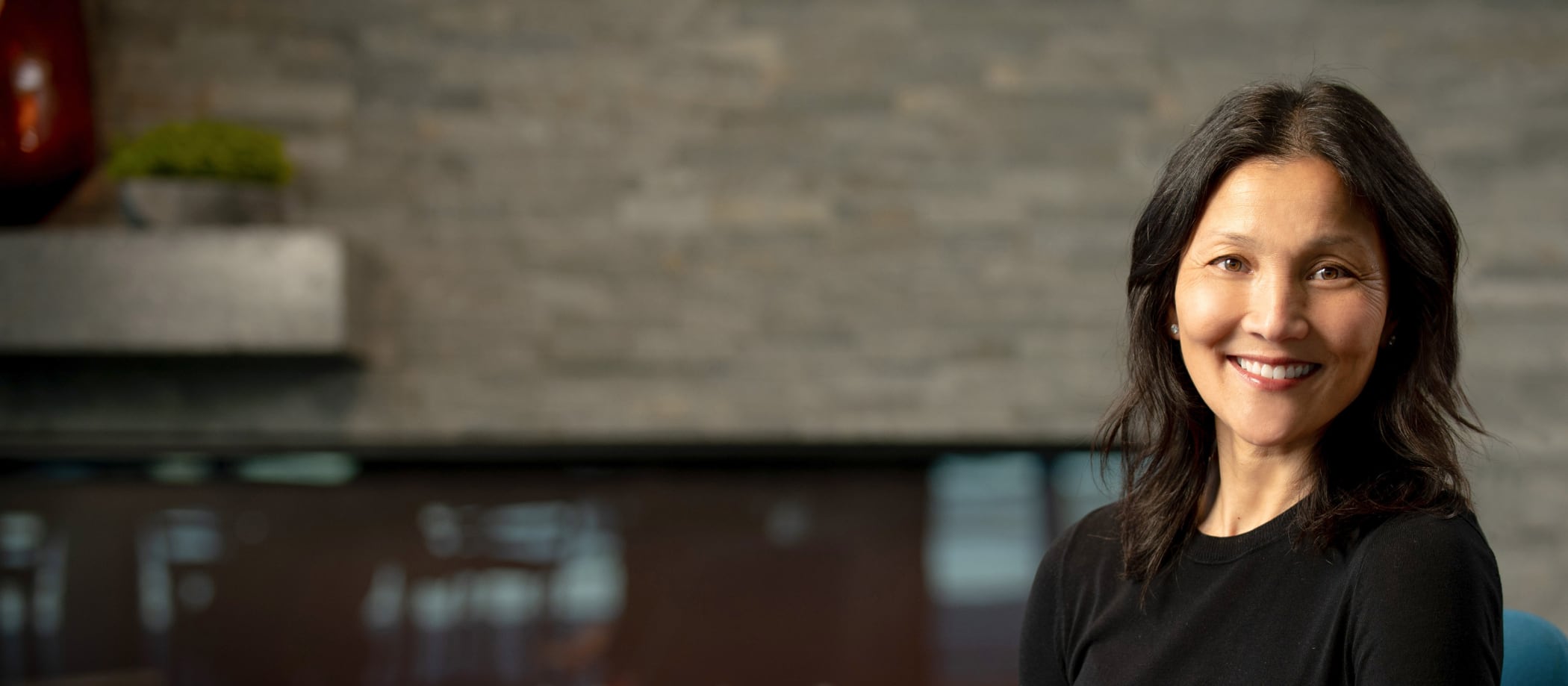 FTI team member smiling in front of a brick wall